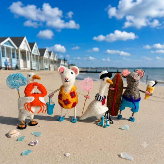 Handmade felt seaside Tiny Animals by Sew Heart Felt, including a rock-pooling mouse and a crabbing duck, on a summer beach background