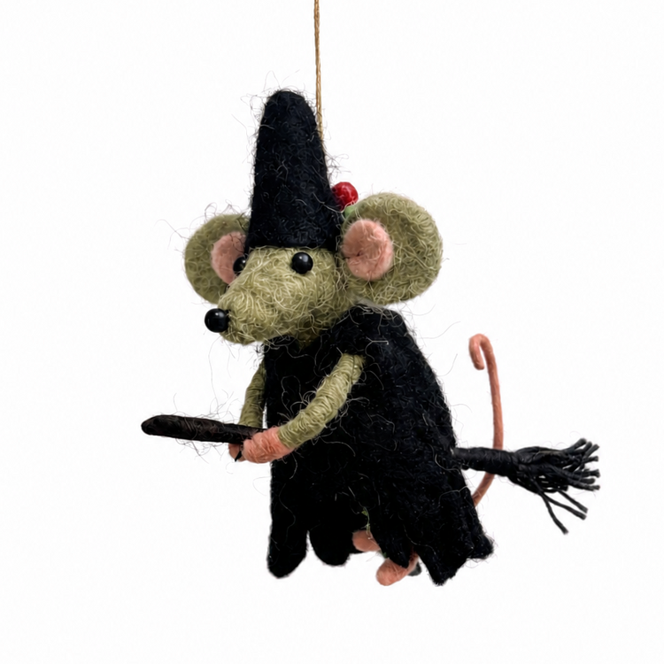 A felted wool witch mouse hanging ornament, featuring a black dress, pointed black hat with a small red bead, olive-green ears and legs, and holding a black broomstick, suspended by a string against a white background.